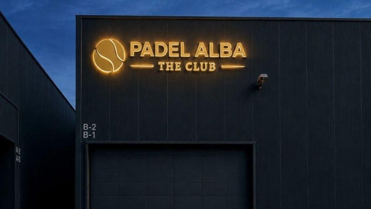 Illuminated Padel Alba The Club sign on the new factory building at dusk