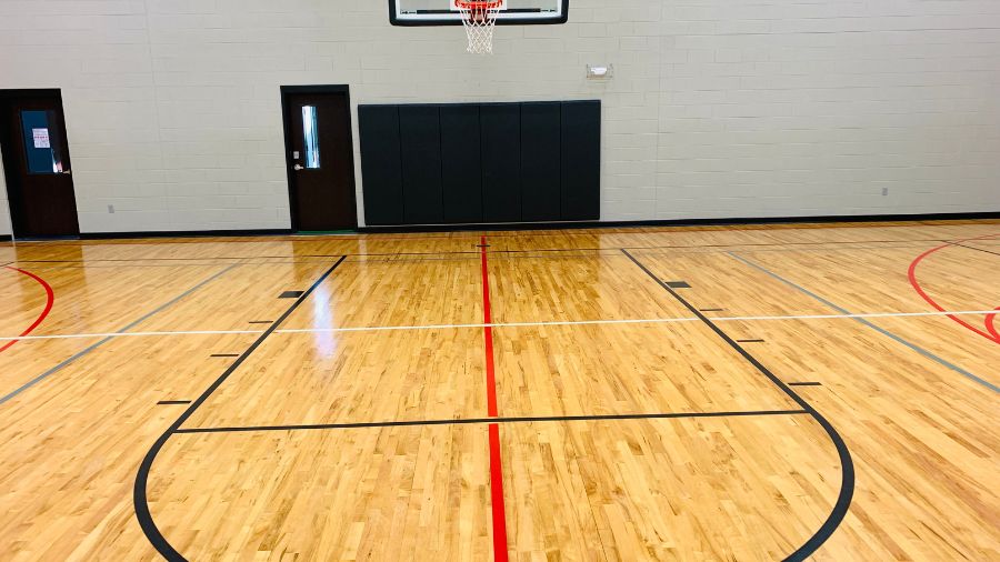 Basketball court with a hardwood floor and padded wall